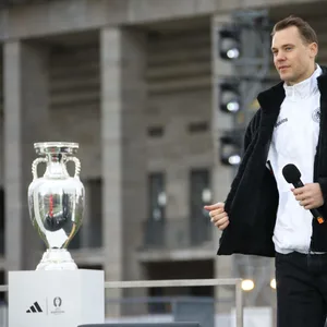 Manuel Neuer mit Mikrofon in der Hand. Links von ihm der EM-Pokal.