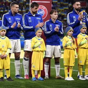 Die italienische Mannschaft klatscht. Vor ihnen stehen die Einlaufender in Ukraine-Trikots