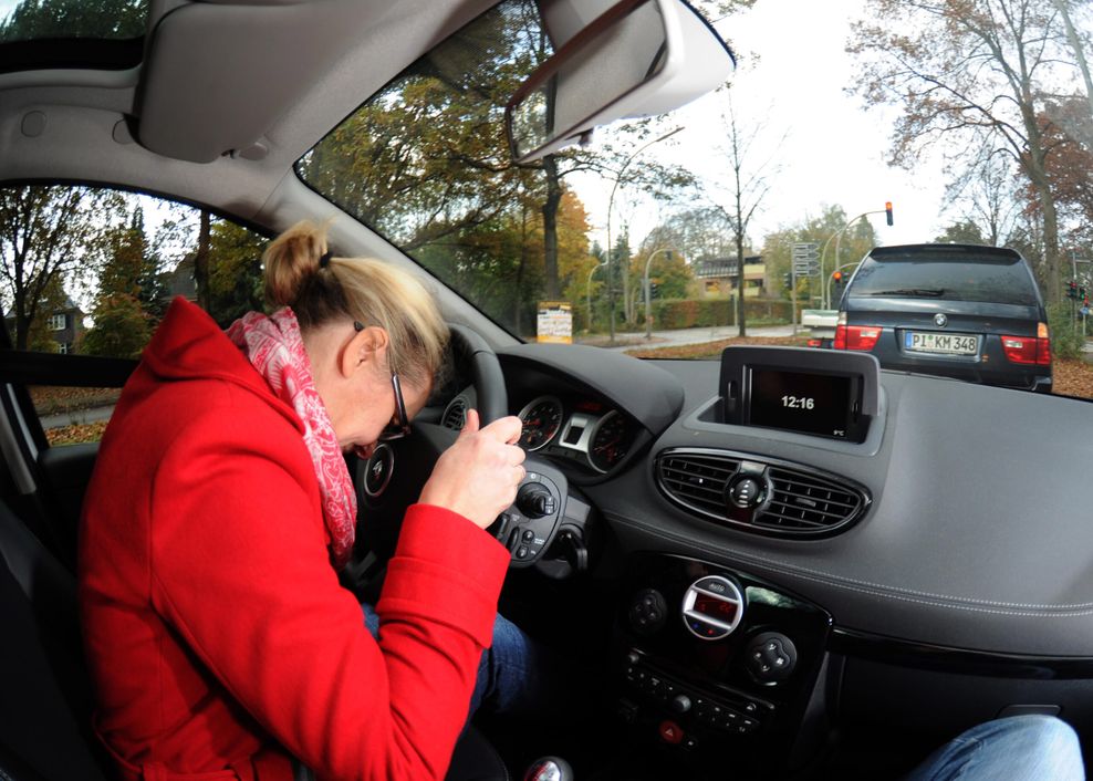 Frau beugt sich über Lenkrad