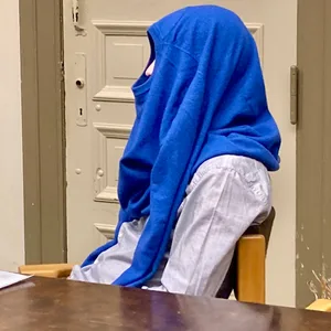 Angeklagter mit Pullover auf dem Kopf