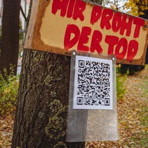 Baum mit Schild „Mir droht der Tod“