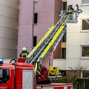 Feuerwehrleute löschen einen Brand in einer Wohnung in Harrislee, bei der eine Frau ums Leben gekommen ist.