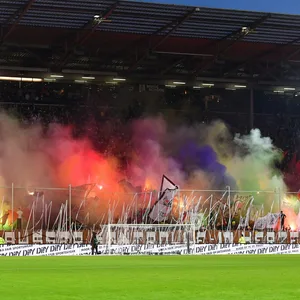 Auf der Südtribüne des Millerntorstadions brennt bunte Pyrotechnik