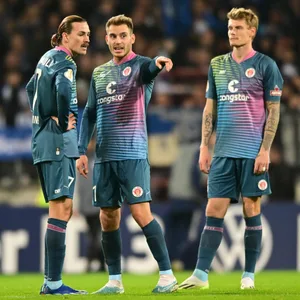 Jackson Irvine, Lars Ritzka und Eric Smith beraten sich beim St. Pauli-Spiel gegen Schalke