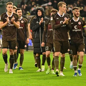 St. Pauli-Profis drehen eine Ehrenrunde und applaudieren.