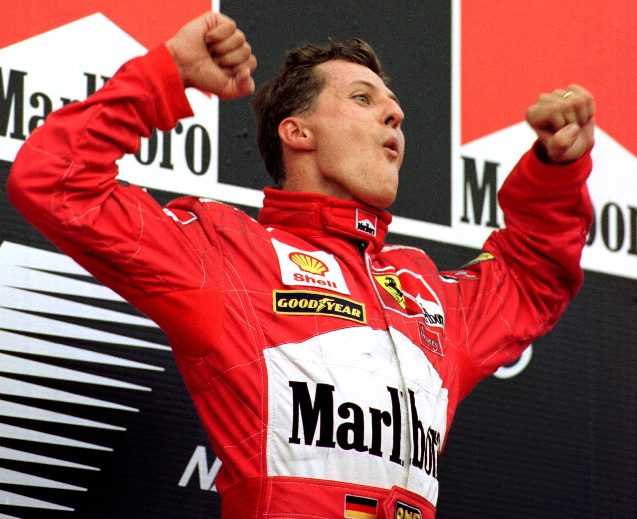Michael Schumacher jubelt bei einer Siegerehrung im Ferrari-Dress.