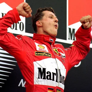 Michael Schumacher jubelt bei einer Siegerehrung im Ferrari-Dress.