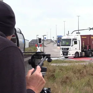 Ein Polizist misst die Geschwindigkeit eines abbiegenden Lkw. (Symbolfoto)