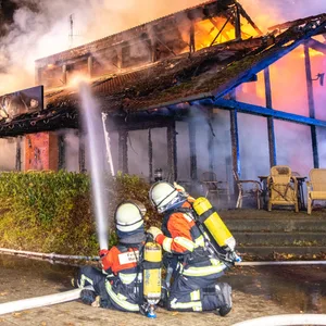 Feuerwehrkräfte löschen den Brand vom Boden und aus der Luft.