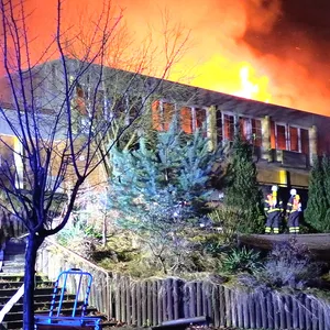Feuerwehrkräfte vor dem brennenden Hotel.