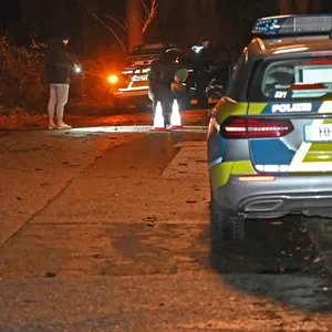 Polizeikräfte in Hausbruch. LKA-Ermittler schauen sich ein aufgefundenes Messer genauer an.