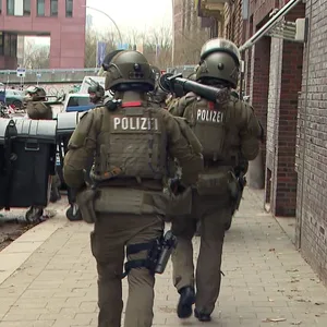 Spezialkräfte verlassen die Wohnung. Es gab den Verdacht, dass ein Mann im Besitz einer Waffe sein könnte.