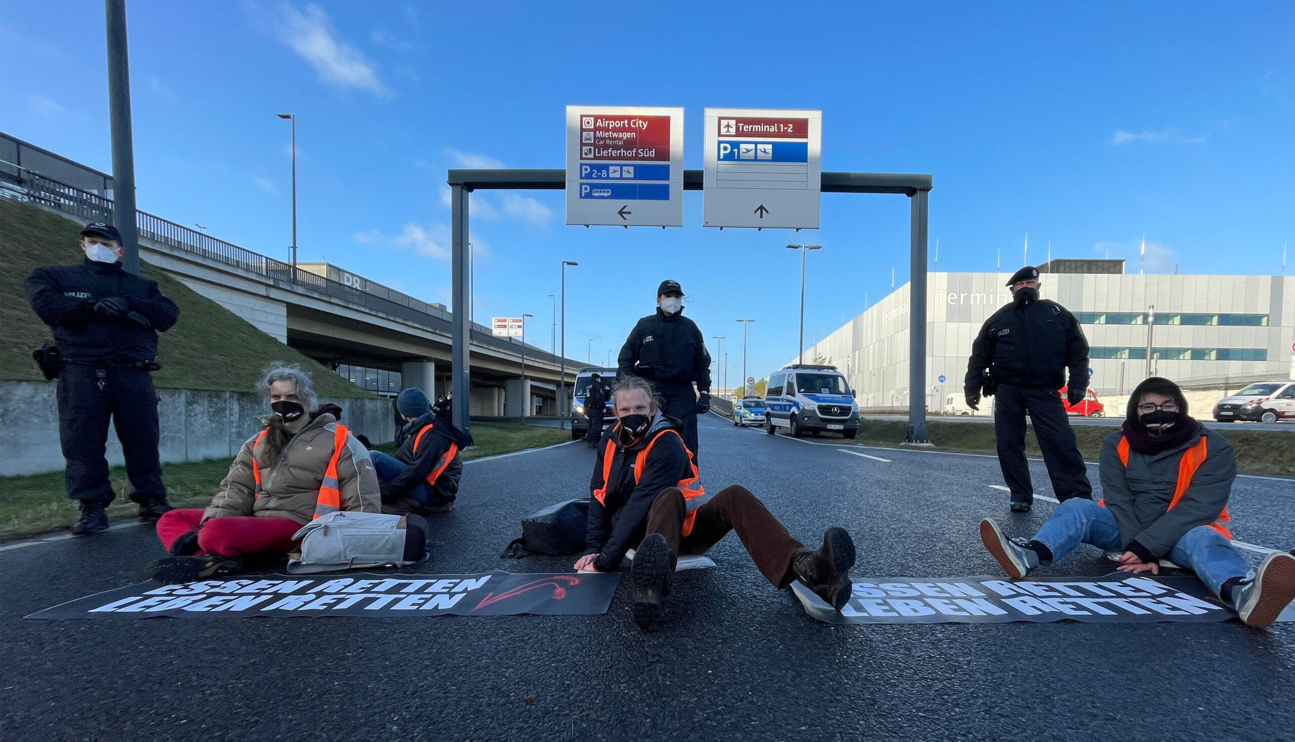 Klimaschutz-Aktivisten der Initiative „Aufstand der letzten Generation“ blockieren eine Zufahrt zum Hauptstadt-Flughafen BER.