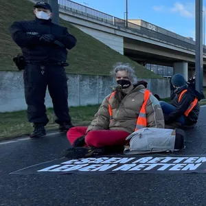 Klimaschutz-Aktivisten der Initiative „Aufstand der letzten Generation“ blockieren eine Zufahrt zum Hauptstadt-Flughafen BER.