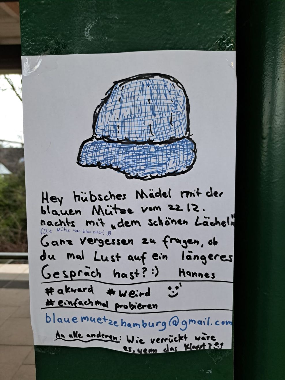 Der handgeschriebene Zettel mit der gezeichneten blauen Mütze