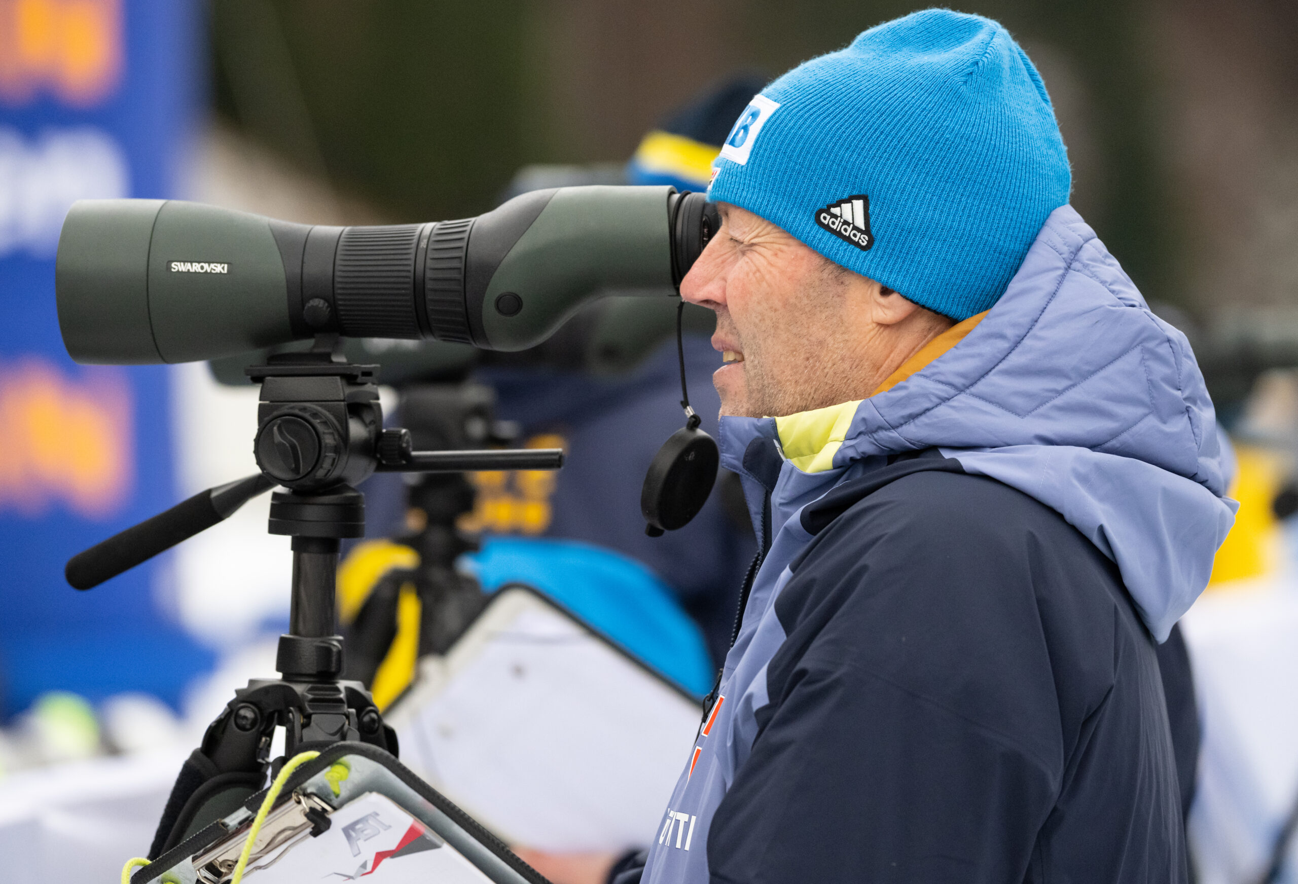 Biathlon-Trainer Uros Velepec schaut durch ein Fernrohr