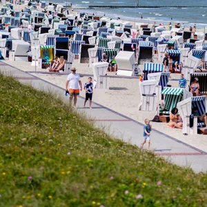 Urlauber in Strandkörben an der Nordseeküste
