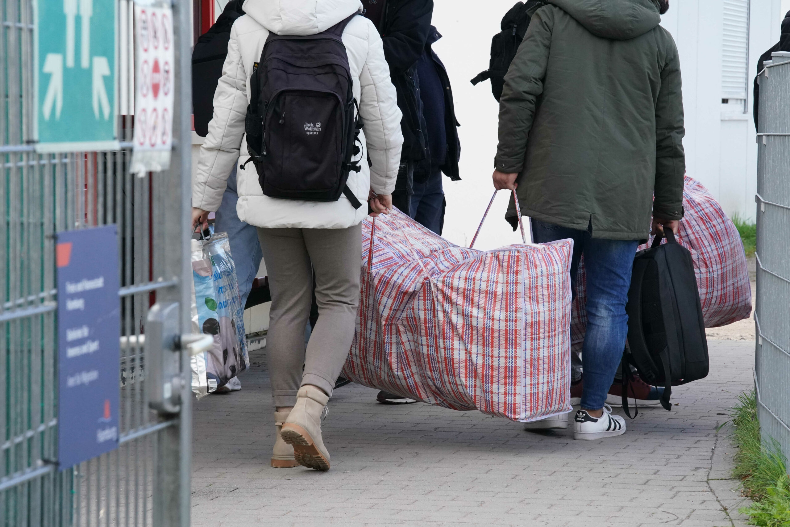 Flüchtlinge kommen mit Taschen und Koffern in einer Erstaufnahmeeinrichtung an