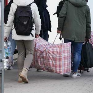 Flüchtlinge kommen mit Taschen und Koffern in einer Erstaufnahmeeinrichtung an