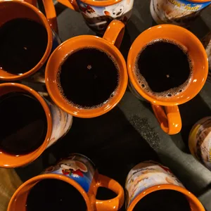 Becher mit Glühwein und Früchtepunsch stehen auf einem Tablett.