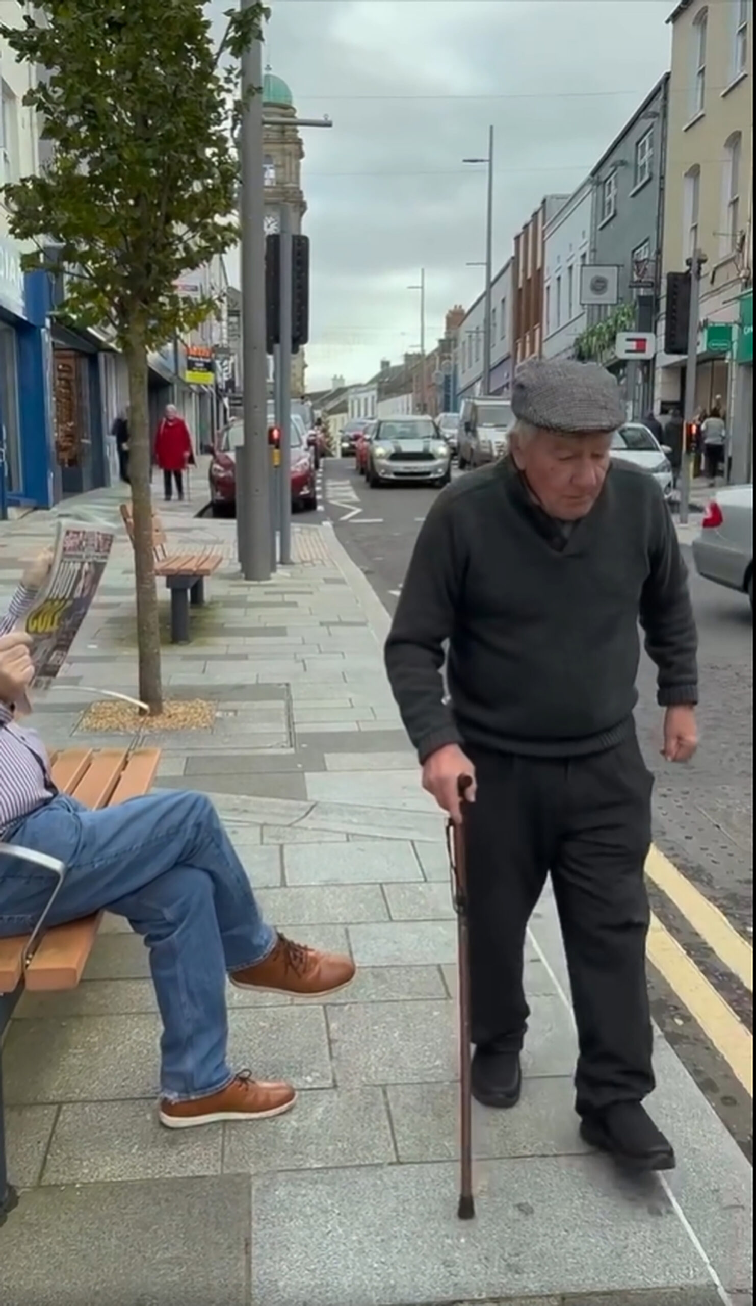 Screenshot aus dem Weihnachtsvideo von „Charlie‘s Bar“: Ein alter Mann auf einem Gehweg