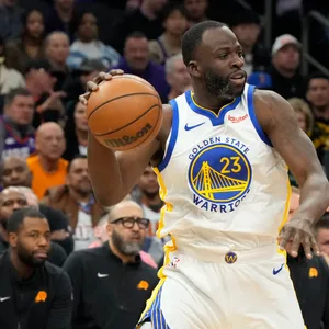 Draymond Green schirmt den Basketball vor Devin Booker ab.