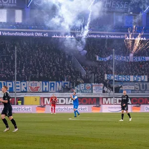 Aus dem Rostocker Gästeblock in Paderborn fliegen Raketen und Leuchtkörper auf das Spielfeld.