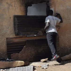 Ein Mann inspiziert nach einem Angriff ein ausgebranntes Haus.