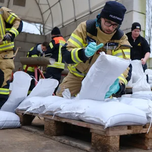 Feuerwehrleute bereiten Sandsäcke vor.