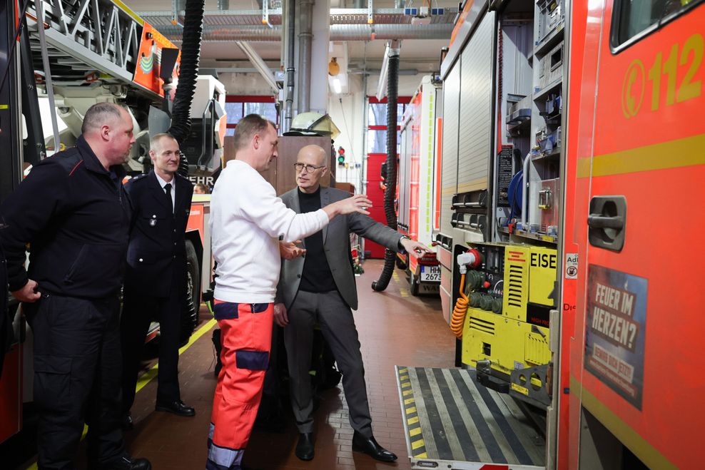 Silvester-Besuch: Peter Tschentscher (SPD, r), Erster Bürgermeister von Hamburg, unterhält sich mit Feuerwehrleuten der Feuer- und Rettungswache F14 in Hamburg-Osdorf