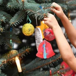 Kind hängt Schmuck an Tannebaum