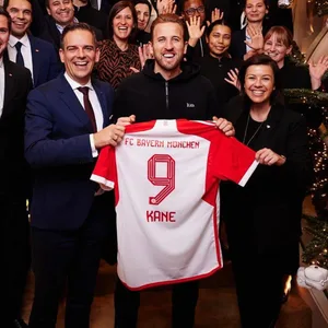 Harry Kane hält sein Trikot in der Hand. Er ist umringt von Mitarbeitern des Hotels Mandarin Oriental.