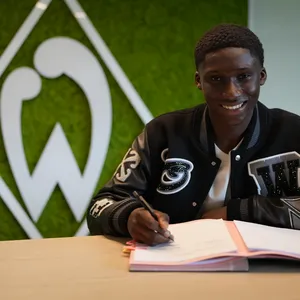 Karim Coulibaly bei seiner Vertragsunterzeichnung für Werder Bremen