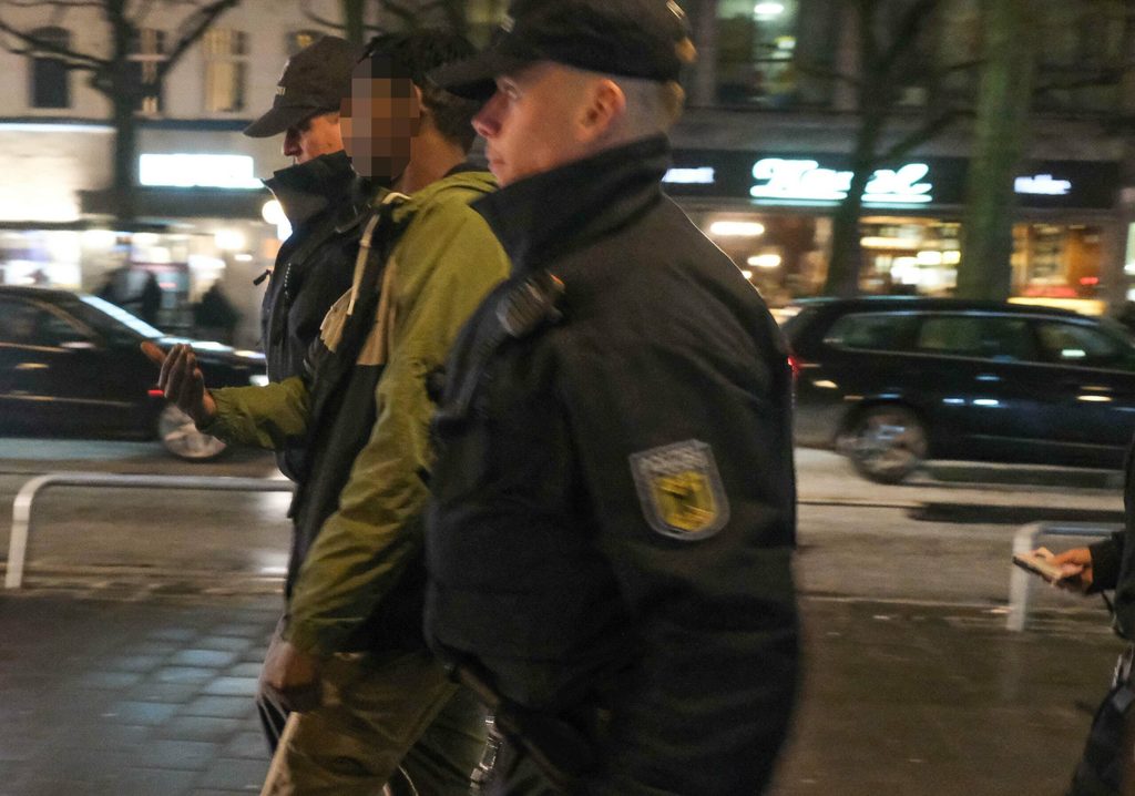 Ein Mann wird abgeführt.