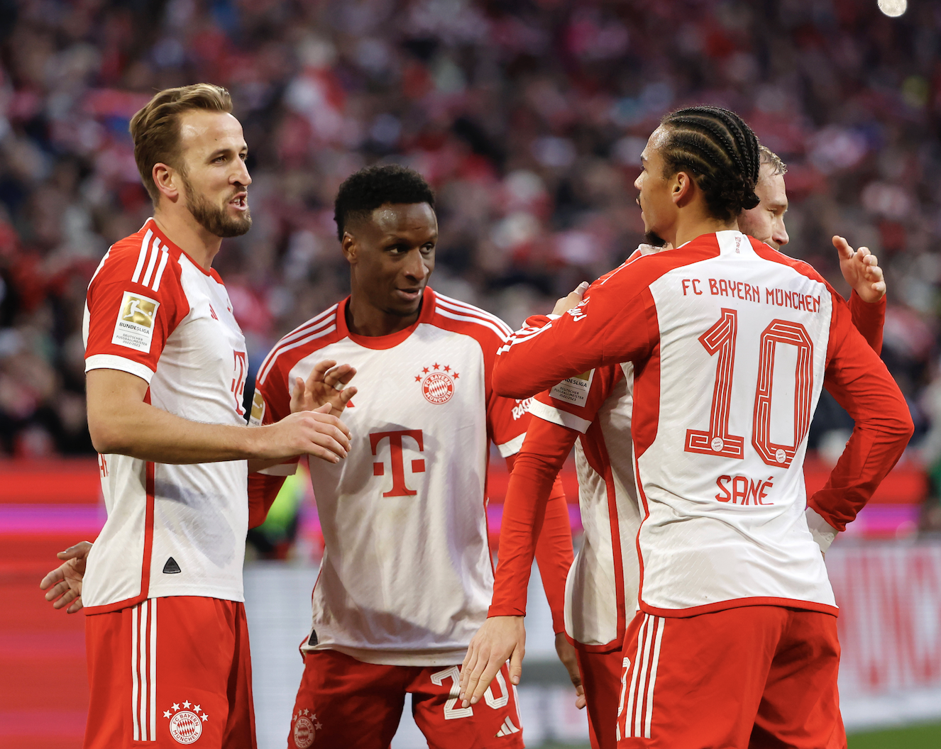 Harry Kane, Bouna Sarr und Leroy Sané bejubeln ein Tor des FC Bayern