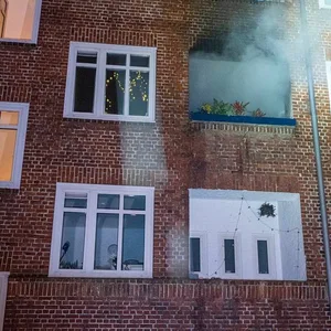 Fassade mit Qualm, der aus einer Wohnung dringt