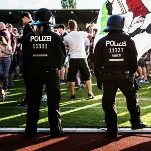 Polizisten beobachten einen Platzsturm im Amateur-Fußball