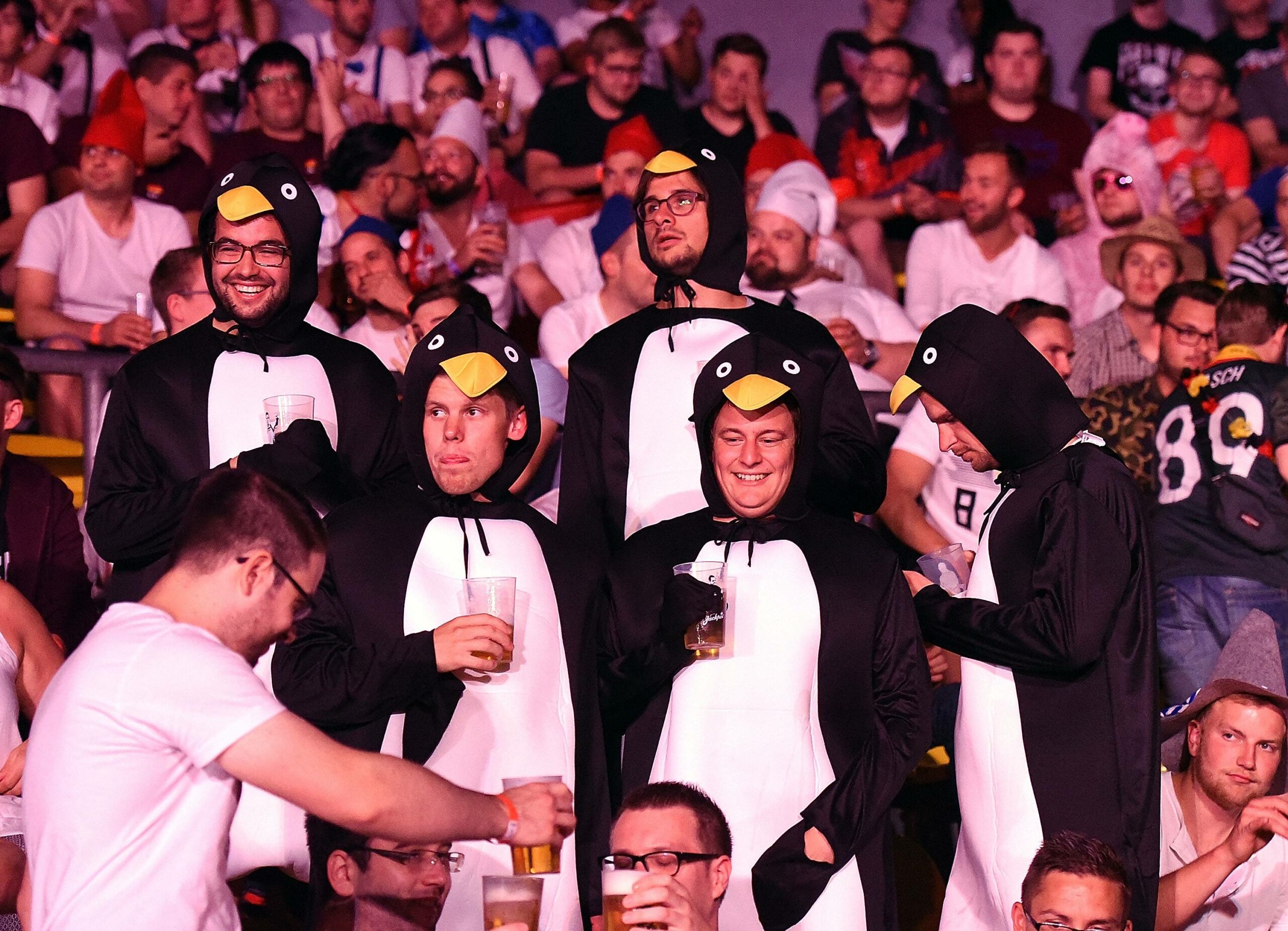 Männer im Pinguin-Kostüm mit Bier in der Hand