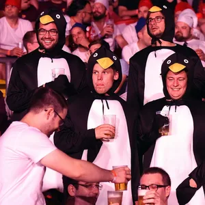 Männer im Pinguin-Kostüm mit Bier in der Hand