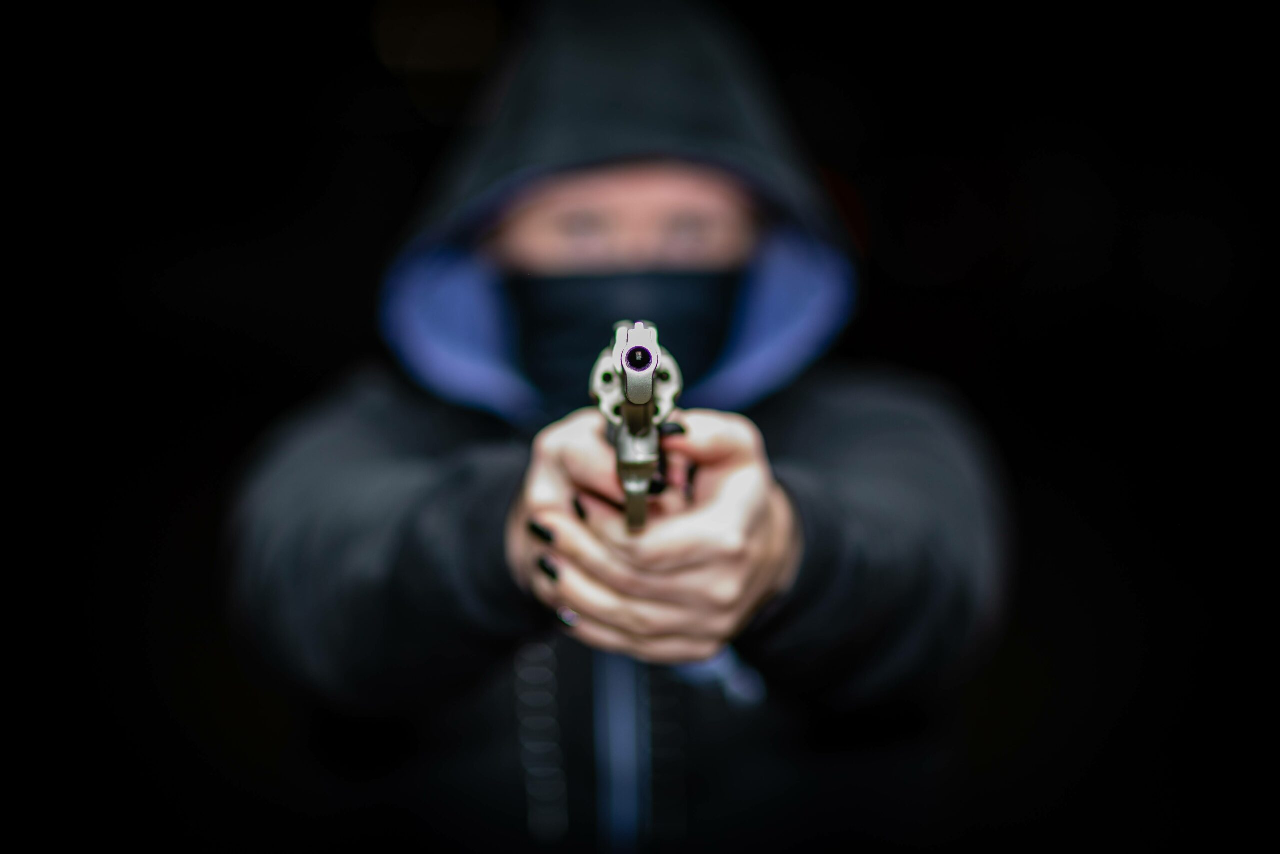 Eine maskierte Frau zielt mit einer Schusswaffe