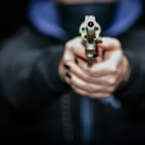 Eine maskierte Frau zielt mit einer Schusswaffe