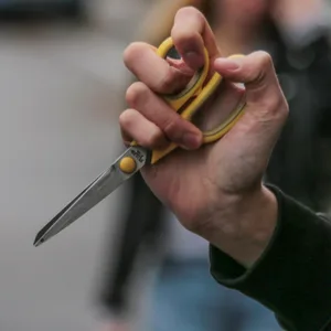 Eine Hand hält eine Schere (Symbolbild)