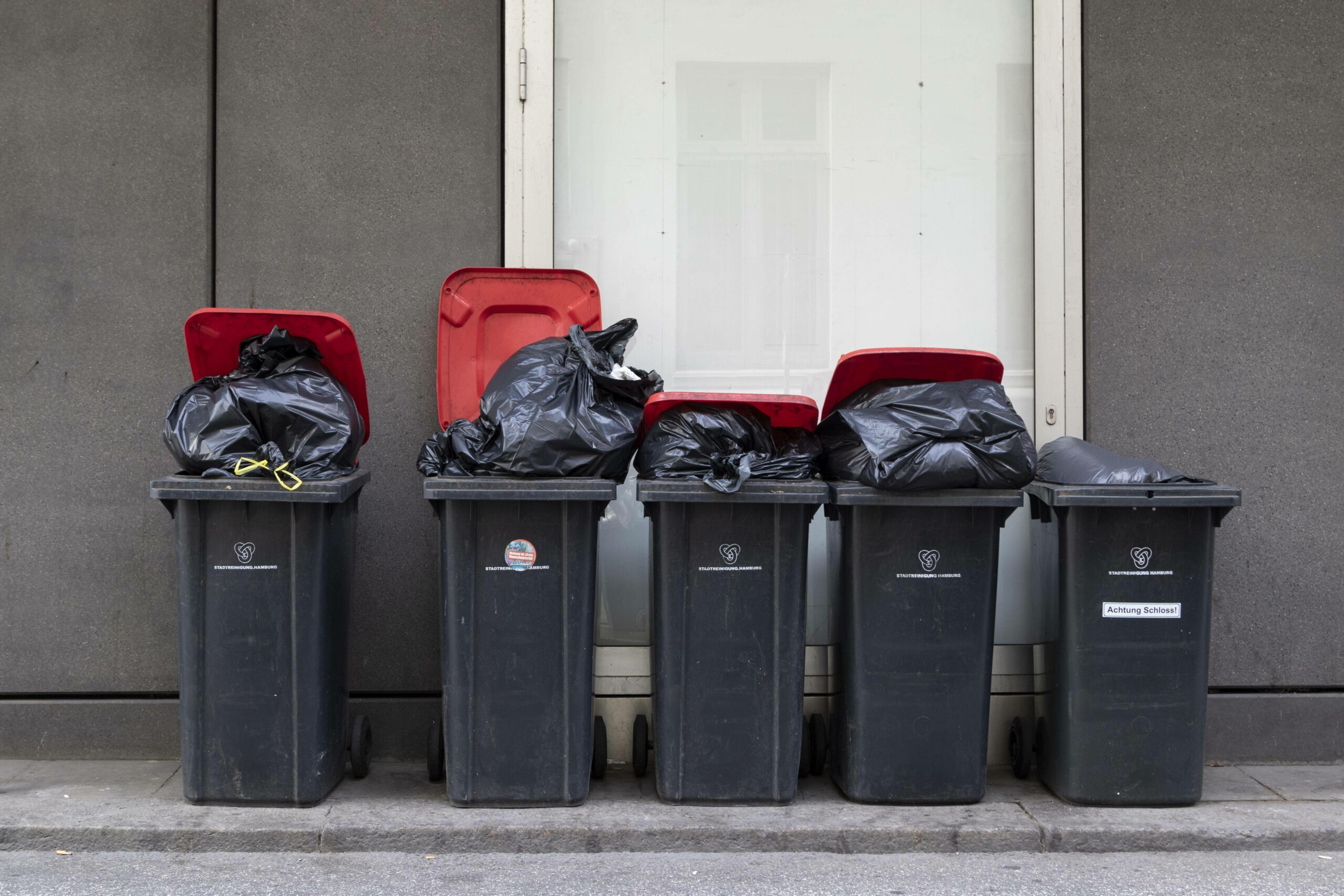 Symbolbild: Mülleimer stehen vor einer Hauswand.