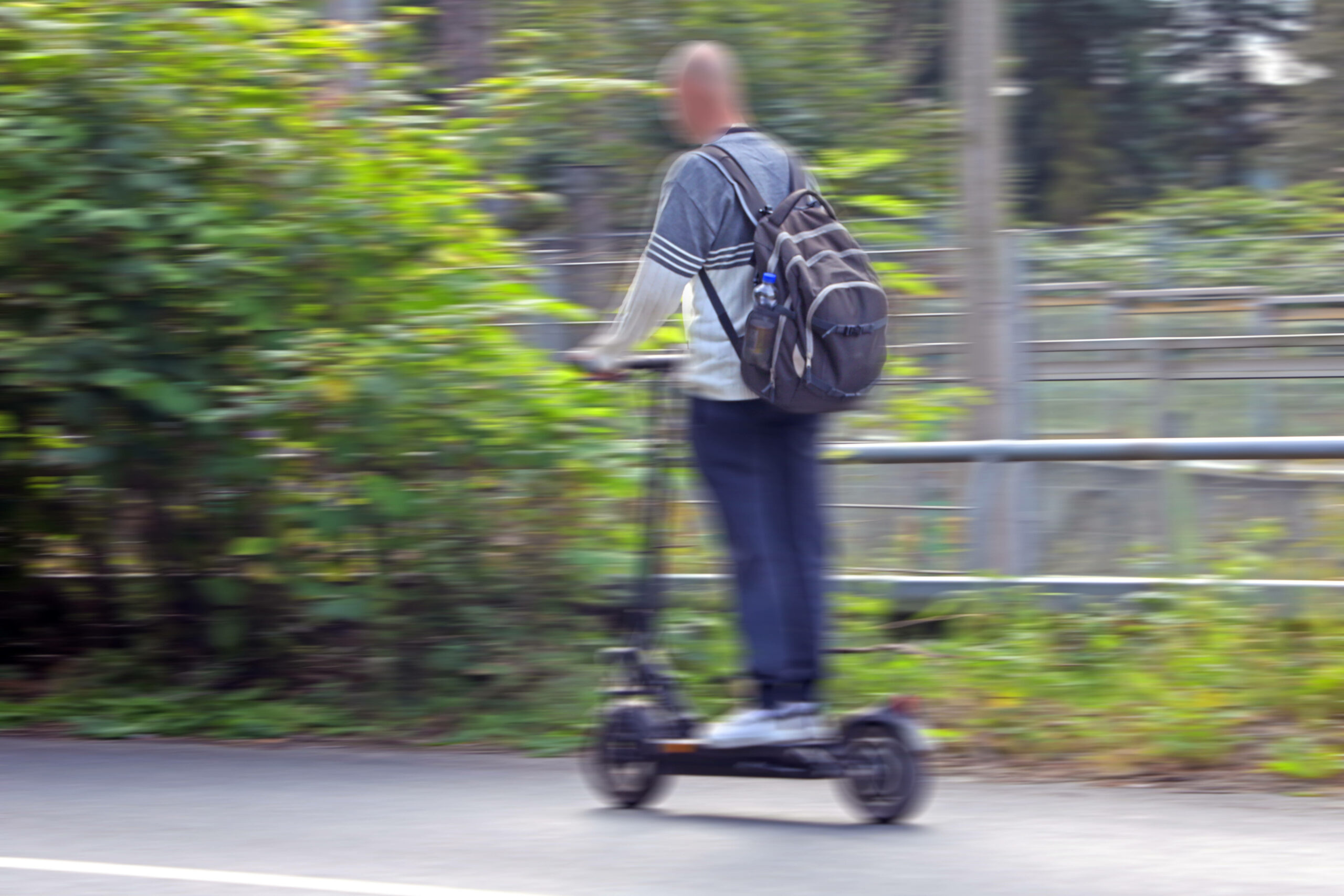 Ein Mann fährt auf einem E-Scooter.