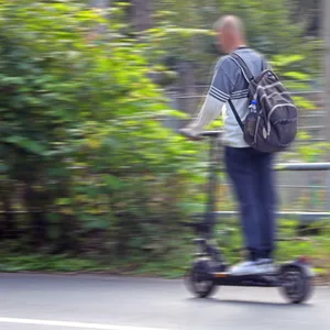 Ein Mann fährt auf einem E-Scooter.