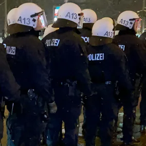 Polizisten im Einsatz stehen auf einer Straße in Hamburg. (Symbolbild)