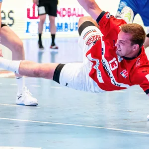 HSVH-Spieler Weller wirft ein Tor im Liegen gegen Lemgo