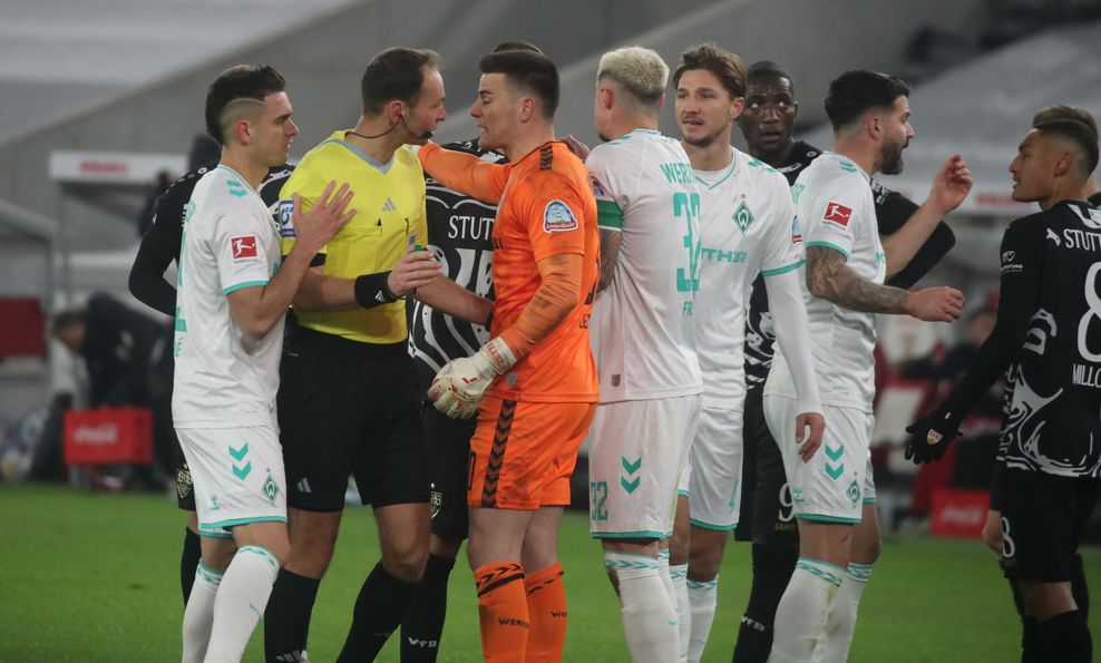 Schiedsrichter Bastian Dankert (l.) umringt von Werder-Torhüter Zetterer (Mitte) und seinen Mitspielern