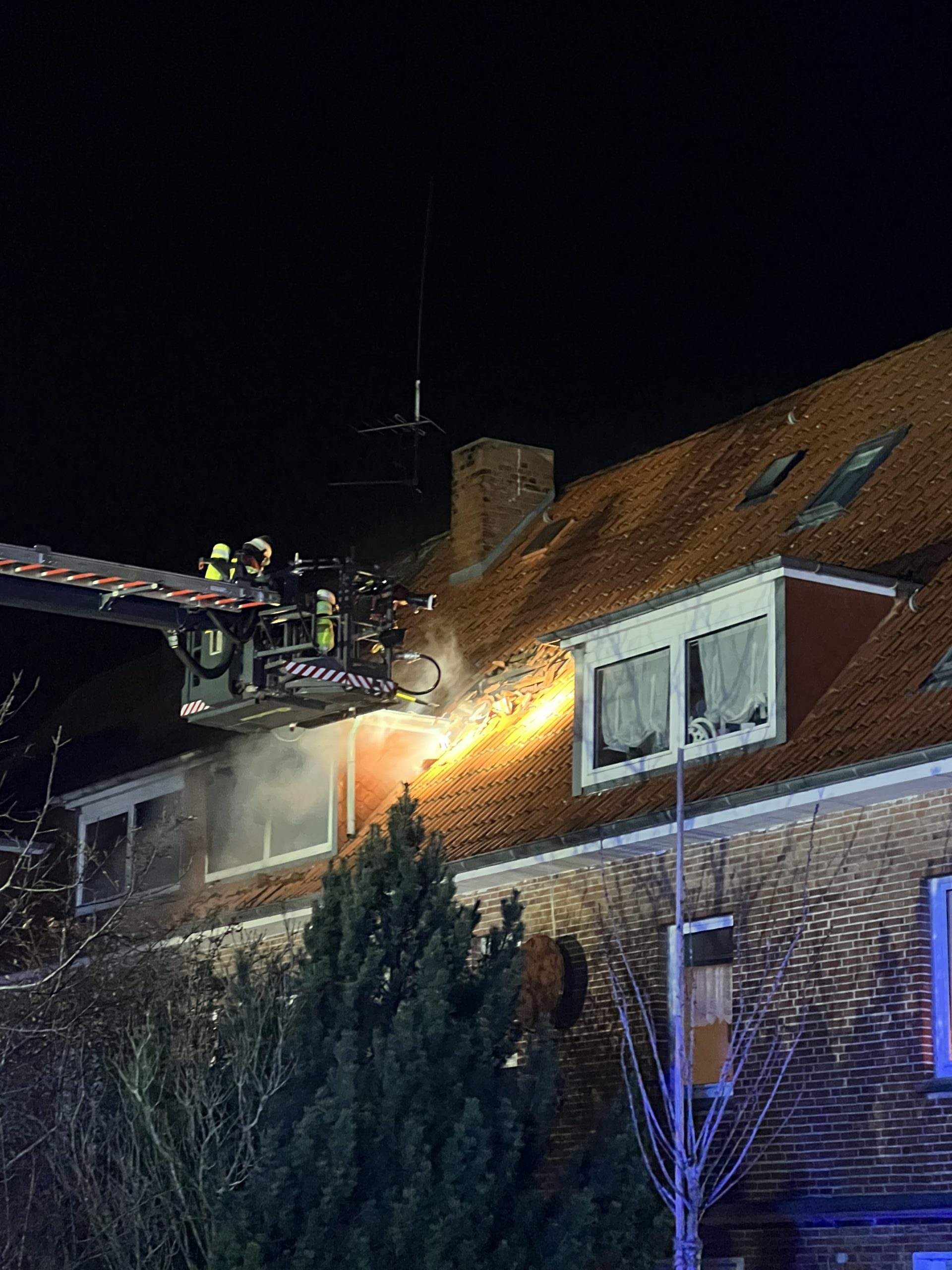 Einsatzkräften an dem brennenden Haus in Mönkeberg