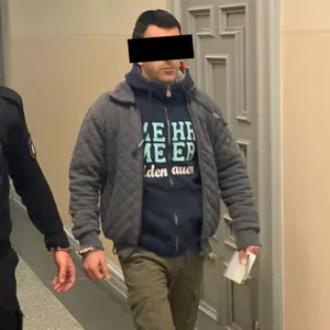 Der Angeklagte wird am Dienstag im Strafjustizgebäude von einem Justizbeamten zum Gerichtssaal geführt.